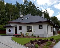 Na terenie, na którym stoi dom, można stawiać budynki z płaskim dachem. Pan Mariusz wybrał tradycyjną bryłę, ponieważ tylko taki projekt spełniał ważne dla niego kryteria &#8211; przy ładnej bryle miał odpowiedni układ wnętrz oraz ogród zimowy. Tak jak sobie życzył, działka ma za plecami las, a wokół panuje cisza i spokój