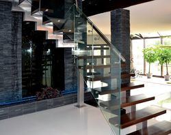 Klatkę schodową wykonano ze szkła, drewna i aluminium. Przy niej znajduje się efektowna ściana wodna, spełniająca rolę nawilżacza powietrza. W całym domu słychać delikatny szum wody. Ścianę tę oświetlają LED-y. Hol ze schodami oddziela od salonu różnica jednego schodka w poziomie podłogi