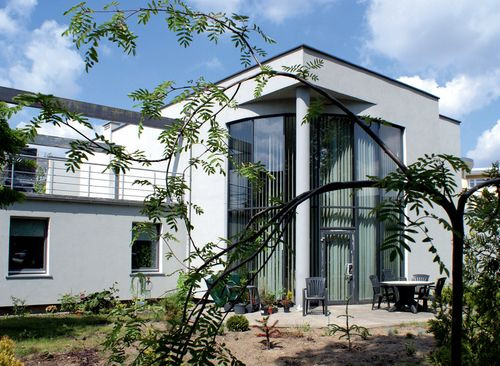 W dużym przeszkleniu pokoju dziennego znajdują się drzwi prowadzące do ogrodu