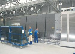 Operatorzy po kolei układają na linii do zespalania odpowiednie formatki szklane.