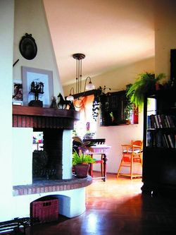 Masywny kominek przesłania kuchenne, &quot;robocze&quot; wnętrze.