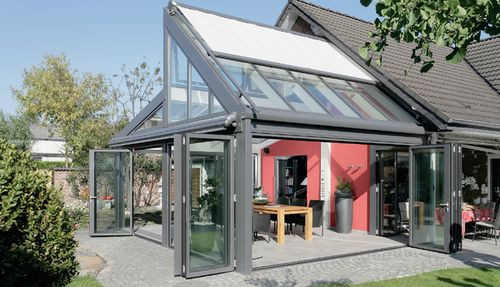 Wygodny solidny duży stół otoczony sześcioma krzesłami sprawia, że szklane pomieszczenie może pełnić wiele funkcji