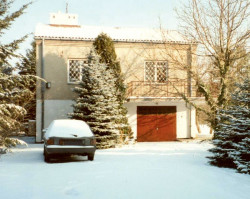 Dom z sutereną i podwyższonym parterem, zawierającym wnętrza mieszkalne, przypominał budynki z poprzedniej epoki. Pokryty był dwuspadowym dachem z płyt eternitu. Na parterze znajdowaly się dwa pokoje, kuchnia, łazienka i sień