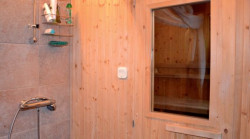 Drzwi sauny obito drewnem świerkowym i wyposażono w szybę hartowaną. Obok sauny jest prysznic