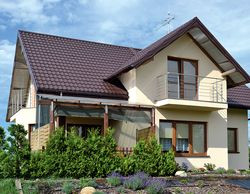 Dwuspadowy dach pokryto blachodachówką w kolorze ciemnego brązu, a elewacje otynkowano akrylowym tynkiem w kolorze ecru. Z jasnym tynkiem kontrastują brązowe ramy okienne. Pozostawiono tylko dwa balkony, południowy i zachodni. Nie zbudowano balkonu od strony wschodniej