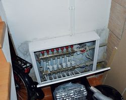 W piwnicy pod schodami znajduje się rozdzielacz centralnego ogrzewania podłogowego. Podobne rozdzielacze znajdują się na każdej z trzech kondygnacji budynku