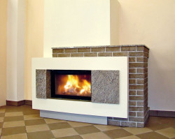 Kominek z wkładem Hajduk Volcano AT standard, do wykończenia obudowy użyto między innymi granitu oraz ręcznie formowanych cegieł.