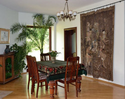 Zabytkowy rodowy gobelin ozdabia jadalnię, sąsiadującą z otwartą kuchnią. Ściany wewnętrzne poprzedni właściciele wykończyli gipsowym tynkiem maszynowym, a nowi pomalowali zmywalną farbą w kolorze kremowym. Posadzki z podłogówką wykończyli płytami terakoty. Resztę posadzek – dębowym parkietem