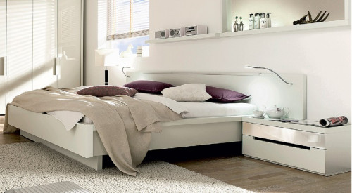 Nowoczesne łóżko Cutaro marki Hülsta wyposażone w zagłówek z oświetleniem.