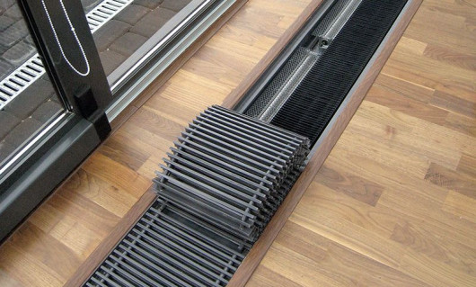 Wzdłuż szerokich okien tarasowych, sięgających do podłogi, idealnie sprawdzają się modele kanałowe, ukryte w podłodze. Grzeją szybko i efektywnie. Tworzą tzw. kurtynę powietrzną i pozwalają wyeliminować zjawisko kondensacji pary wodnej na przeszkleniach.