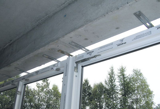 Montaż skrzydła okiennego na konsolach wsporczych, przytwierdzanych do muru za pomocą kotew