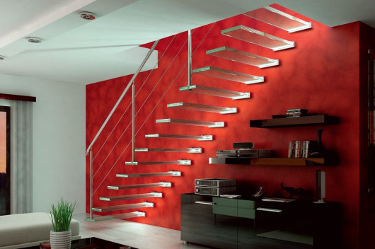 Schody wspornikowe o stopniach z wielowarstwowego szkła laminowanego, mocowanych do ściany za pomocą rotuł, które – podobnie jak balustradę – wykonano ze stali nierdzewnej