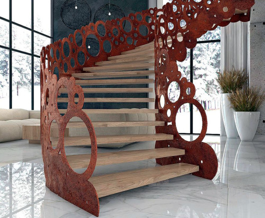 Schody z drewnianymi stopniami i niezwykłą ażurową balustradą ze stali kortenowej