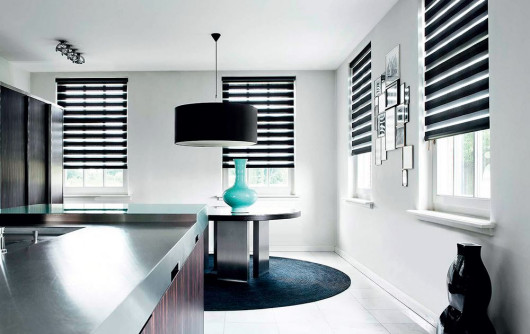 Rolety Essential typu dzień-noc marki Coulisse, dostępne w prowadnicach lub jako wolno wiszące.