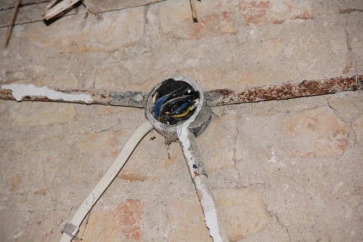 Stara instalacja układana w metalowych rurkach po skuciu tynku