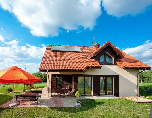 Dom z kolektorami słonecznymi i panelami fotowoltaicznymi