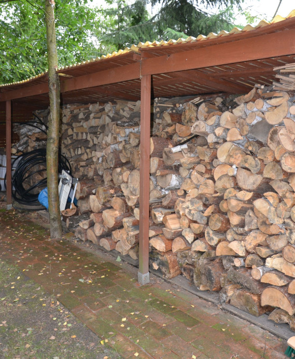 Drewno opałowe schnie w obszernej drewutni