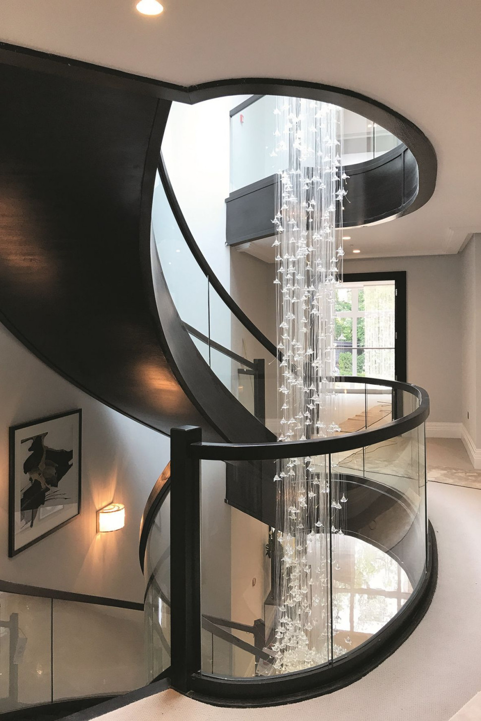 Efektowne połączenie bardzo ciemnego drewna z lekką balustradą z giętego szkła