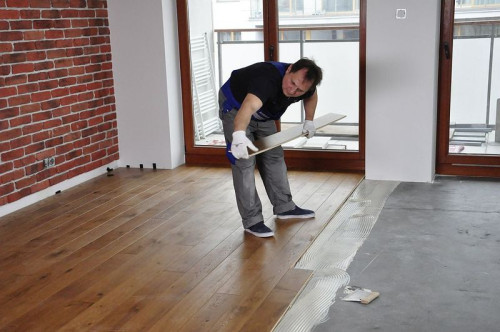 Układanie kolejnych rzędów desek podłogi warstwowej.jpg