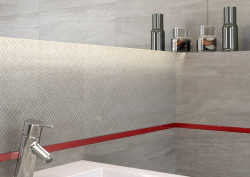 Miłośnicy smaczków w łazience będą zachwyceni połączeniem neutralnej palety szarości z głęboką czerwienią szklanych dekoracji Glass Border