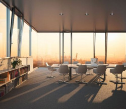 Widok wnętrza biurowego z innowacyjną fasadą Schüco FWS 60 CV zintegrowaną z oknami rozwierno-uchylnymi, w której różnice pomiędzy przeszkleniami stałymi, a otwieranymi są niedostrzegalne Fot. Schüco