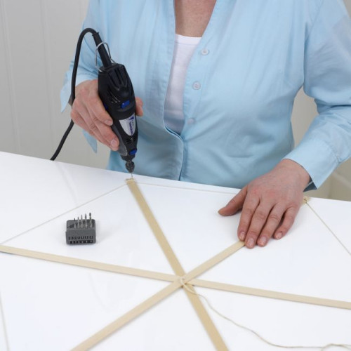 Aby wykonać wędzidło pomagające sterować latawcem w powietrzu, użyj narzędzia wielofunkcyjnego Dremel 200 z uchwytem uniwersalnym i precyzyjnym wiertłem