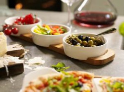 Czteroczęściowy zestaw na dodatki zawierający trzy miseczki i deskę do serwowania