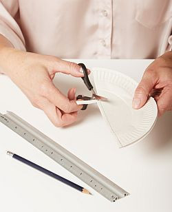 Przyłóż stalową linijkę wzdłuż prostej krawędzi i użyj kostki introligatorskiej do zaznaczenia wgłębienia na całej długości talerzyka