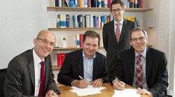 Dr. Harald Braasch (z lewej), Peter Thorning (w środku) i Thomas Stürzl (z prawej) z notariuszem Daniel Wassmann (drugi od prawej) podczas uroczystości podpisania umowy Joint Venture