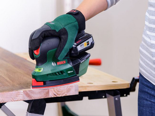 Ostrożnie oszlifuj krawędzie płyt drewnianych akumulatorową szlifierką uniwersalną