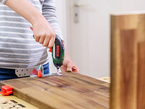 Zamocuj płytę pionową po przeciwnej stronie za pomocą ścisku stolarskiego i umieść kątownik montażowy we właściwej pozycji