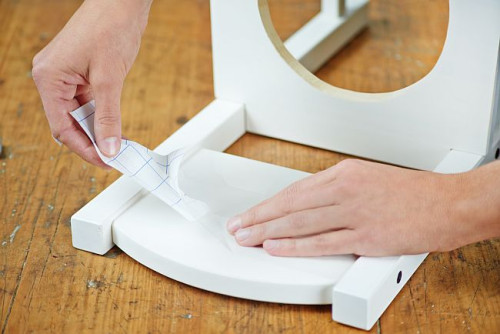 Przyklej folię z wyciętym kształtem kości na oparciu krzesła