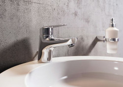 Nowoczesna bateria wyposażona w regulator ceramiczny i automatyczny korek spustowy idealnie współgra z niewielką umywalką nablatową