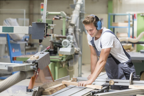 Młody stolarz podcza praktyki zawodowej