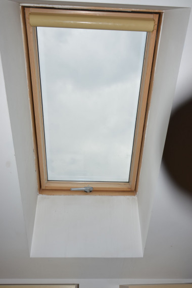 Zwinięta roleta na oknie dachowym