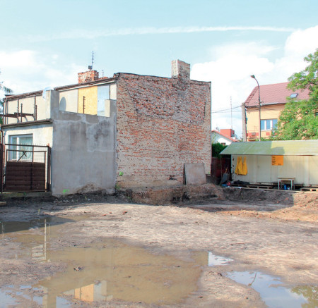 Kilkudziesięcioletni budynek, do którego zostanie doklejony bliźniaczo nowy dom. W dole na granicy działek widać pozostałości fundamentu budynku, który kiedyś stał na tej posesji.