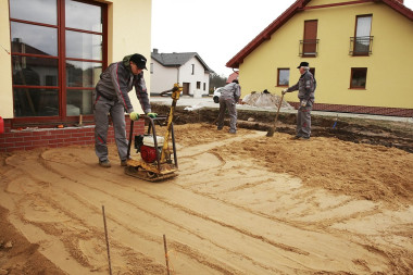 Budowanie tarasu: Mechaniczne zagęszczanie piasku formującego spadek