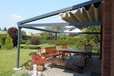 Zadaszenie tarasu - pergole z proszkowo malowanego aluminium, na których zamocowano rozkładany dach z odpornego na wodę, trudno zapalnego włókna