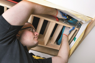 Wykonujemy w skrzynce 2 otwory montażowe, przez które przykręcamy ją do stropu