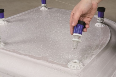 Montaż kabiny prysznicowej: przykręcamy nóżki do spodu brodzika