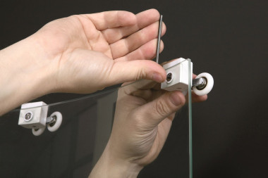 Montaż kabiny prysznicowej: zamocowanie systemów jezdnych na drzwiach i umieszczenie całości w kabinie