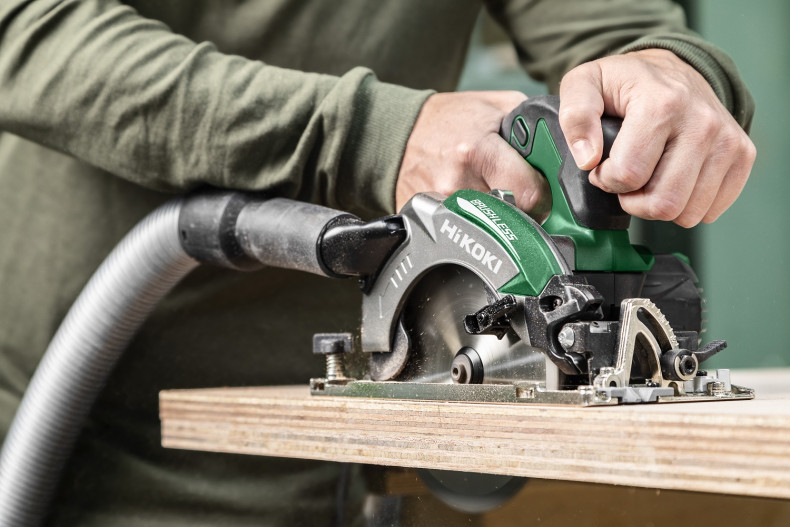 Pilarka podłączona króćcem do odkurzacza pochłaniającego pył