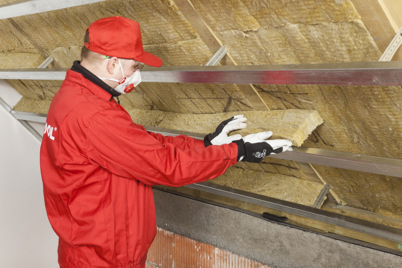 Ocieplanie dachu: zamocowanie do wieszaków profili nośnych i wypełnienie ich izolacją