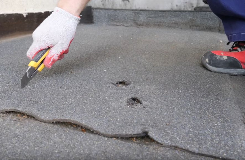 Naprawa pokrycia z papy przed zimą - Uszkodzoną część papy odcinamy nożykiem i zrywamy (usuwamy)