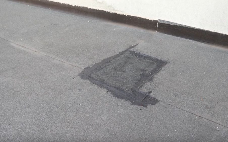 Renowacja pokrycia dachowego z papy przed zimą - Wsuwamy docięty kawałek tak, aby powstała zakładka i uzupełniamy lepik w miejscach, które tego wymagają. Całość dociskamy.