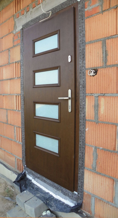 Drzwi wejściowe obsadzone w warstwie nośnej ściany dwuwarstwowej