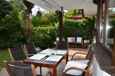 Płyty gresu na tarasie zadaszonym markizą