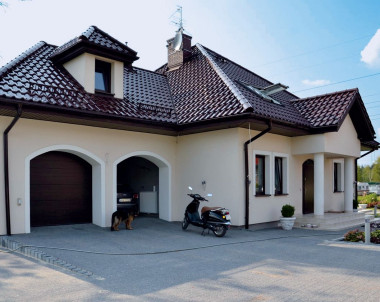 Dom ma tradycyjną bryłę z elementami dworku polskiego