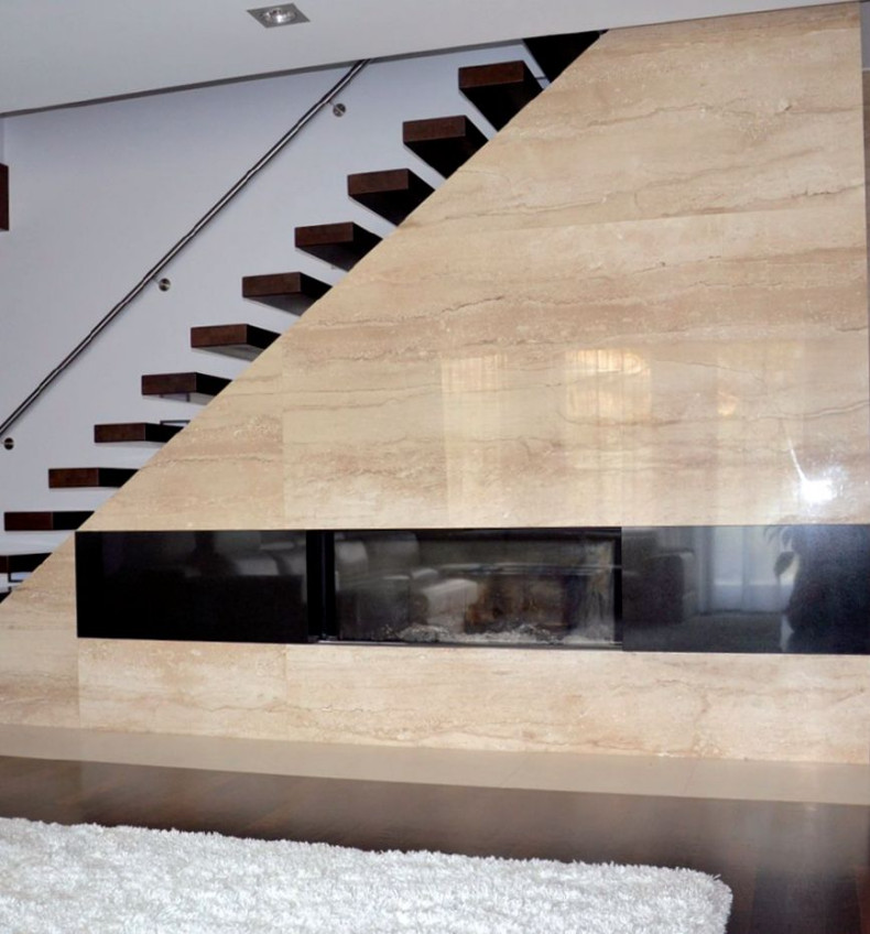 Kominek z wkładem obudowano płytami marmuru botticino i czarnego granitu indian black