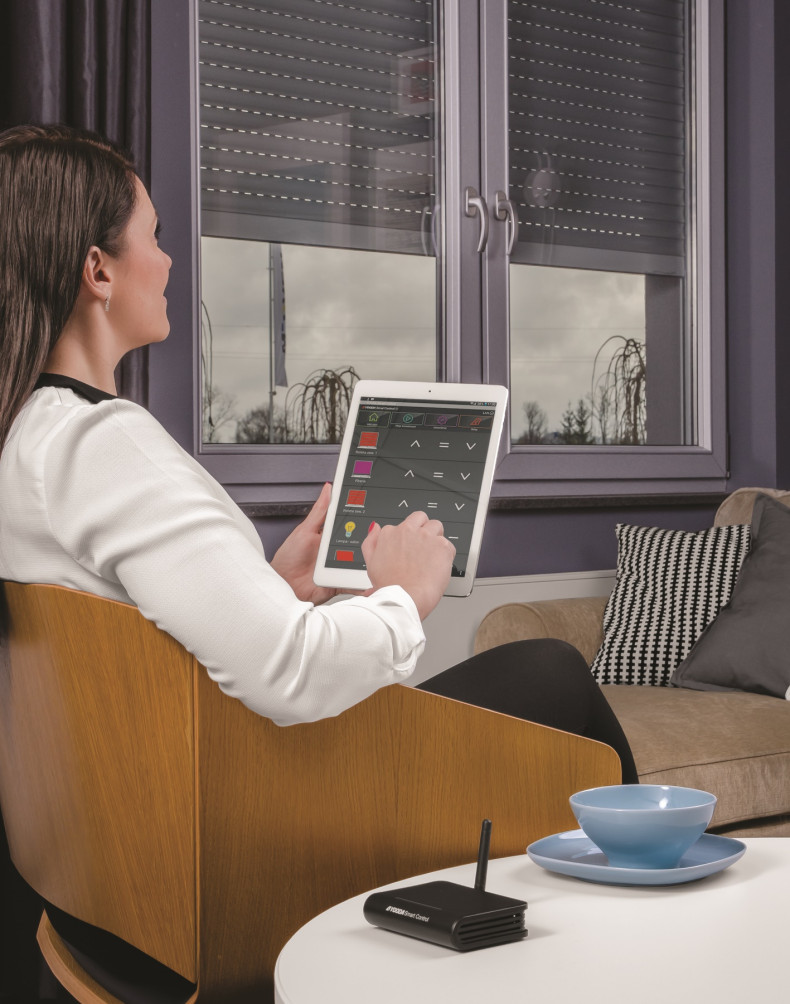 Kobieta steruje roletami za pomocą tabletu